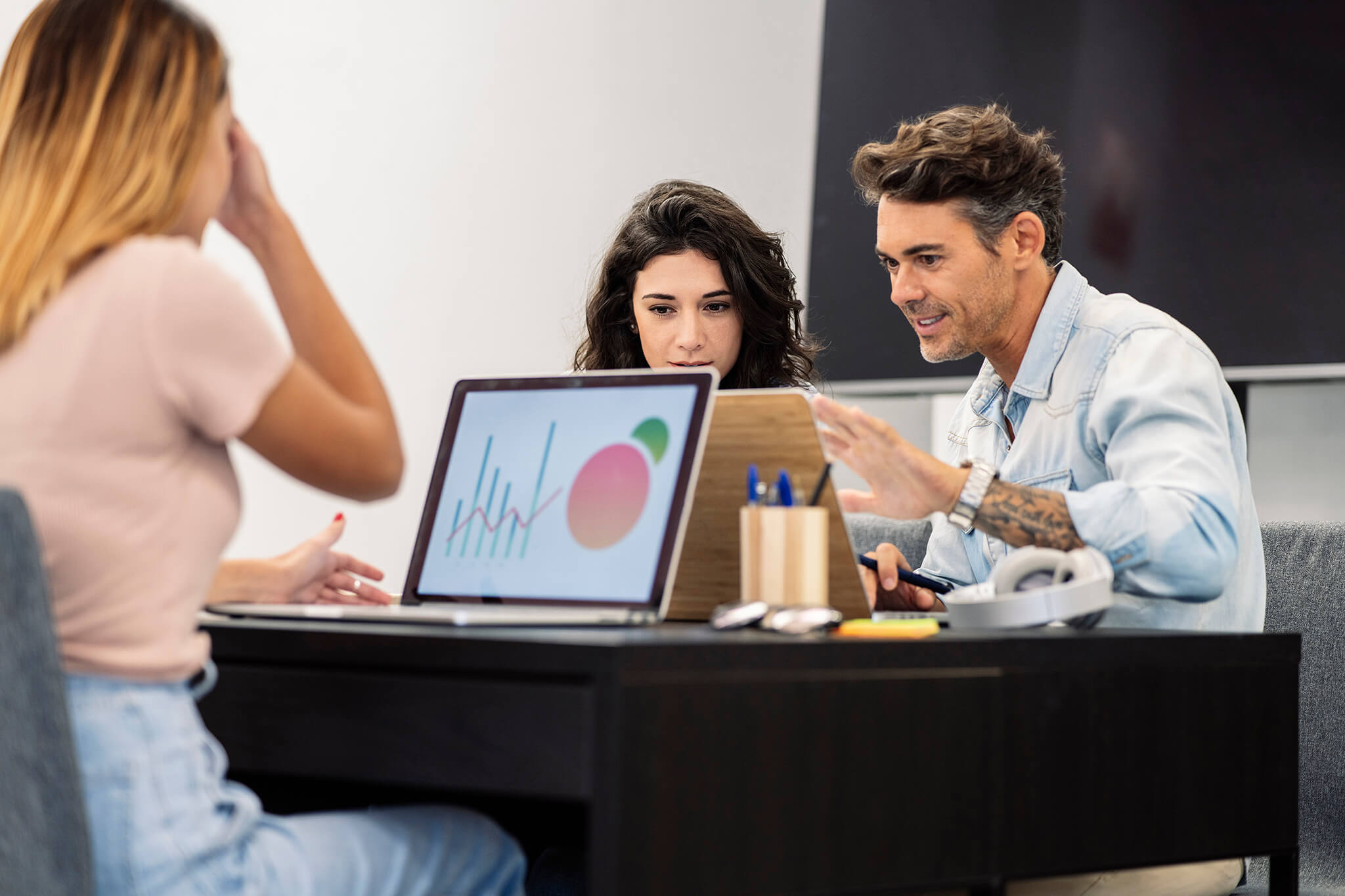 Female coworkers in coworking with computers mature man and you