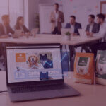 Laptop showing Vitalin dog food Amazon results with 81% sales growth, 200% more units and 125% more repeat customers in a team meeting room.