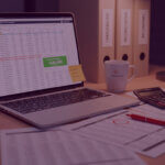 Laptop showing an Amazon chargeback reconciliation spreadsheet highlighting £125,000 recovered, with calculator, paperwork and chargeback folders on a desk.