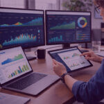 Marketing professional analysing Amazon Ads performance dashboards on multiple screens using a tablet in a modern office workspace