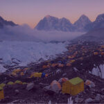 High-altitude base camp tents at sunrise, illustrating Andy Banks’ Light Fund charity challenges.