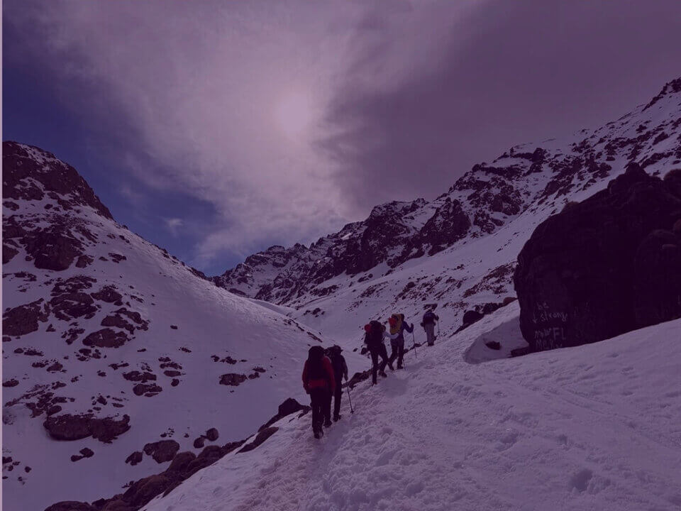 Fundraisers hiking through snowy mountain landscape in support of The Light Fund charity challenge